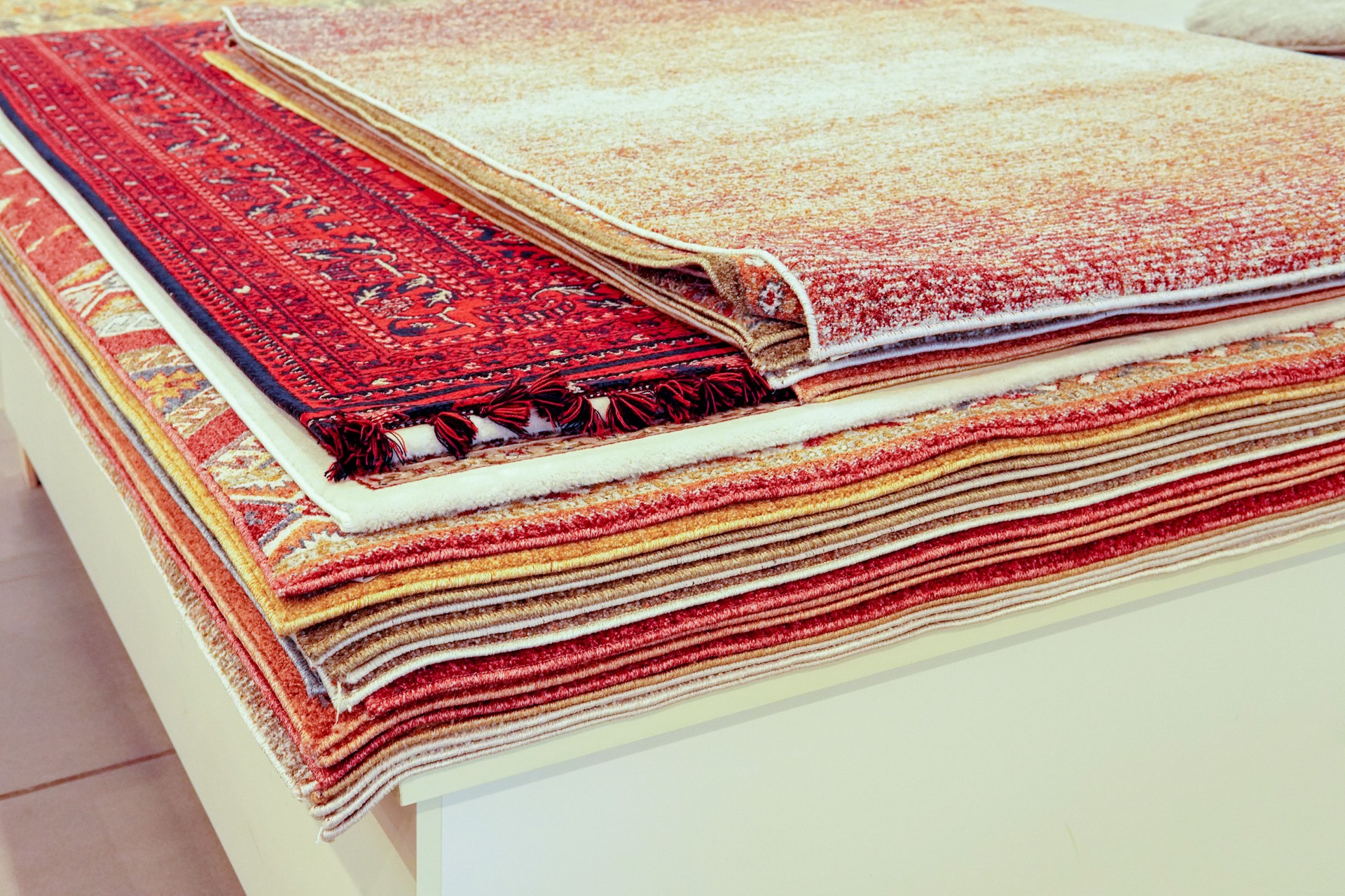 Variety of rugs for sale in different colors and textures.
