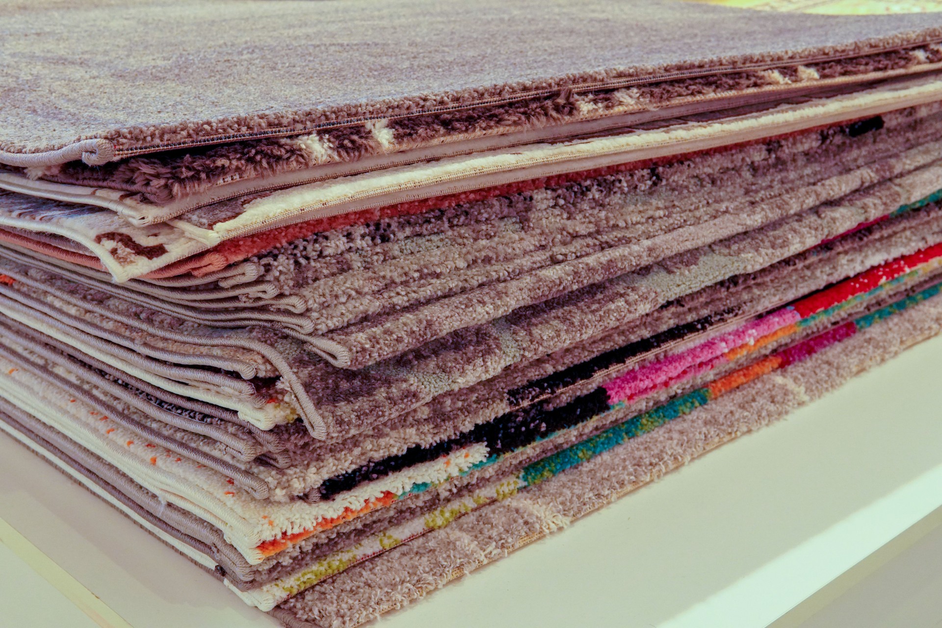Variety of rugs for sale in different colors and textures.