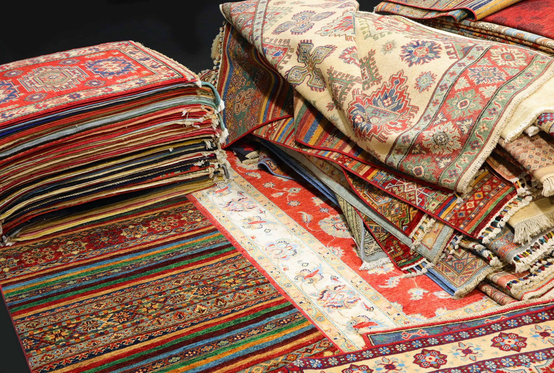 pile of Persian and other rugs for sale in the shop specializing in home furnishings